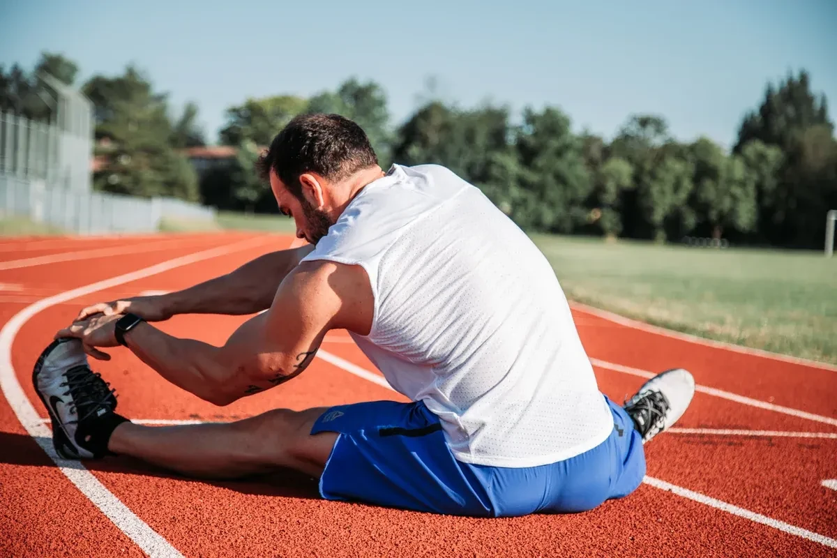 Male athlete stretching on a running track