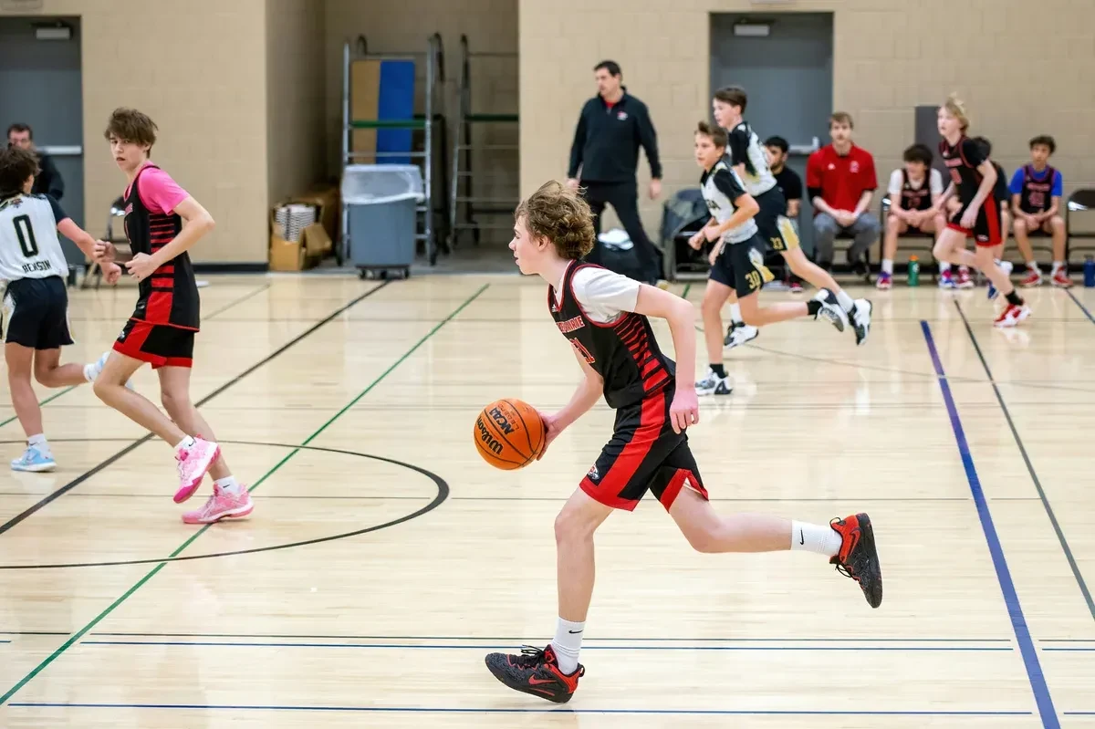 Youth basketball game on a basketball court indoors