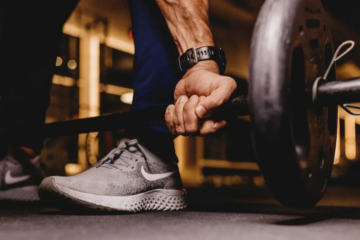 Male trainer lifting a weight in the gym