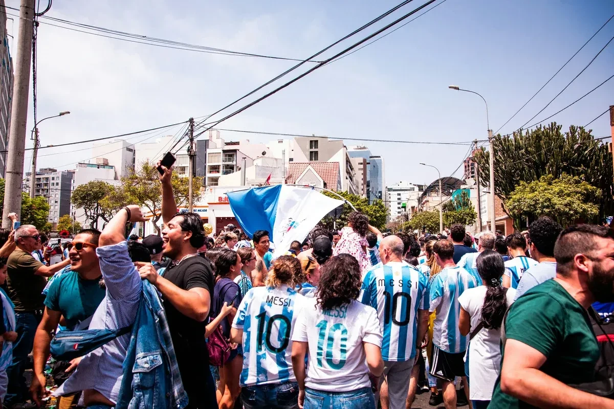Soccer fans outside walking to the stadium and some are wearing Lionel Messi jerseys